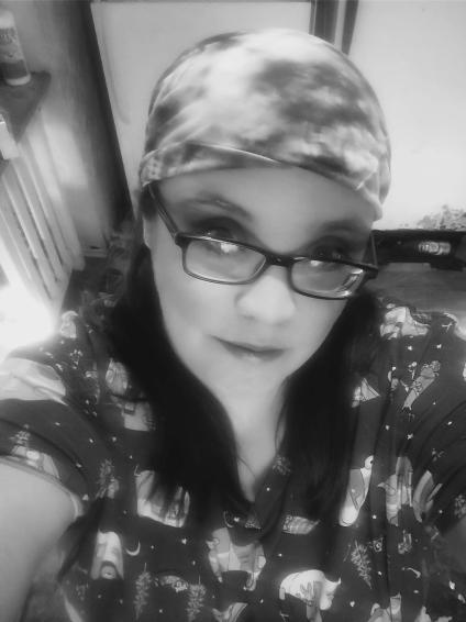 Black and white photo of Jeri, who is wearing a head wrap and glasses